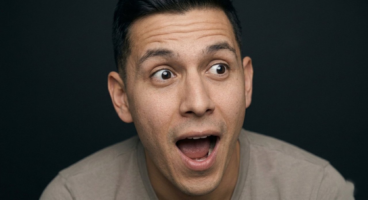 A man's face showing amazement: eyes wide, mouth open in delight.