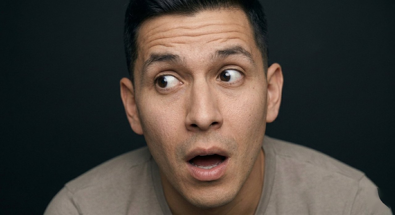 A man's face showing astonishment: eyes wide, mouth open, gaze lifted.