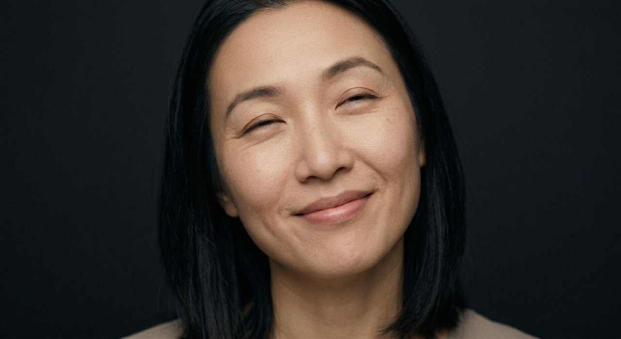 A woman's face showing bliss: a soft closed smile, relaxed eyes, calm and settled.