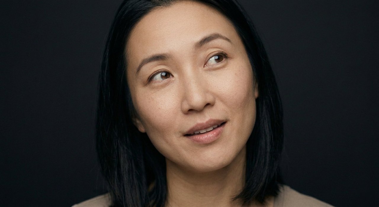 A woman's face showing enchantment: a charmed sidelong gaze and a soft, captivated smile.