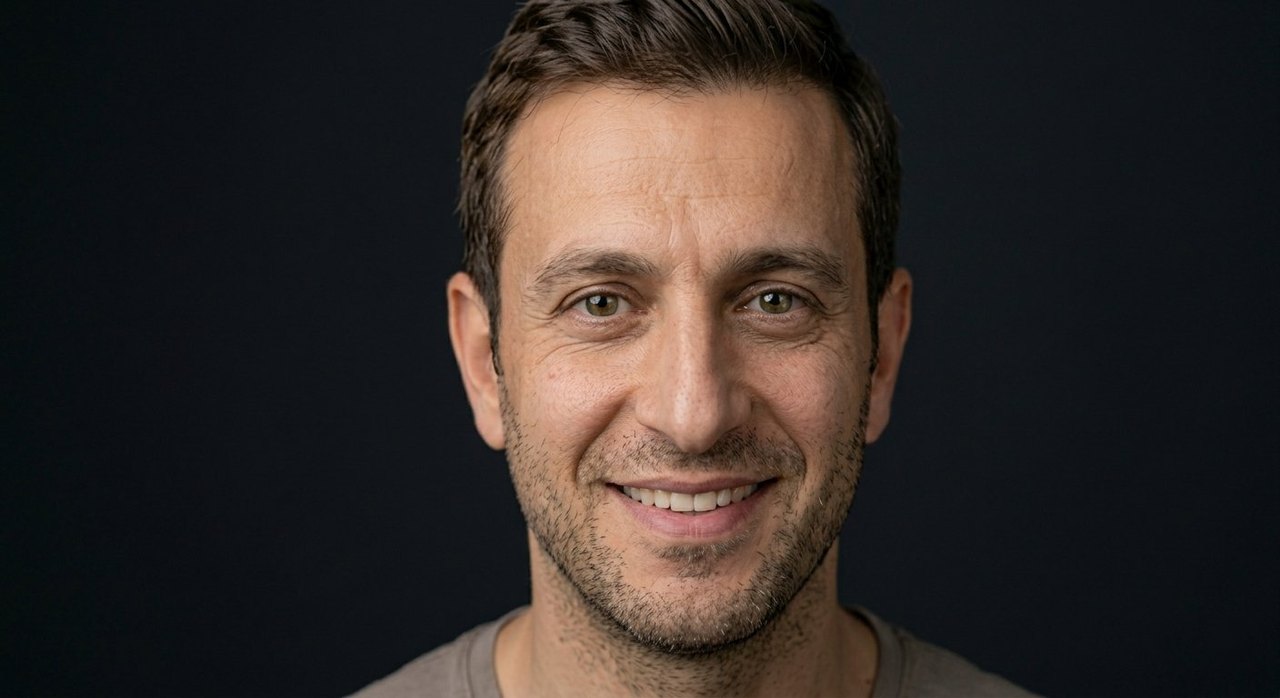 A man's face showing inspiration: a bright smile and uplifted eager lit eyes.