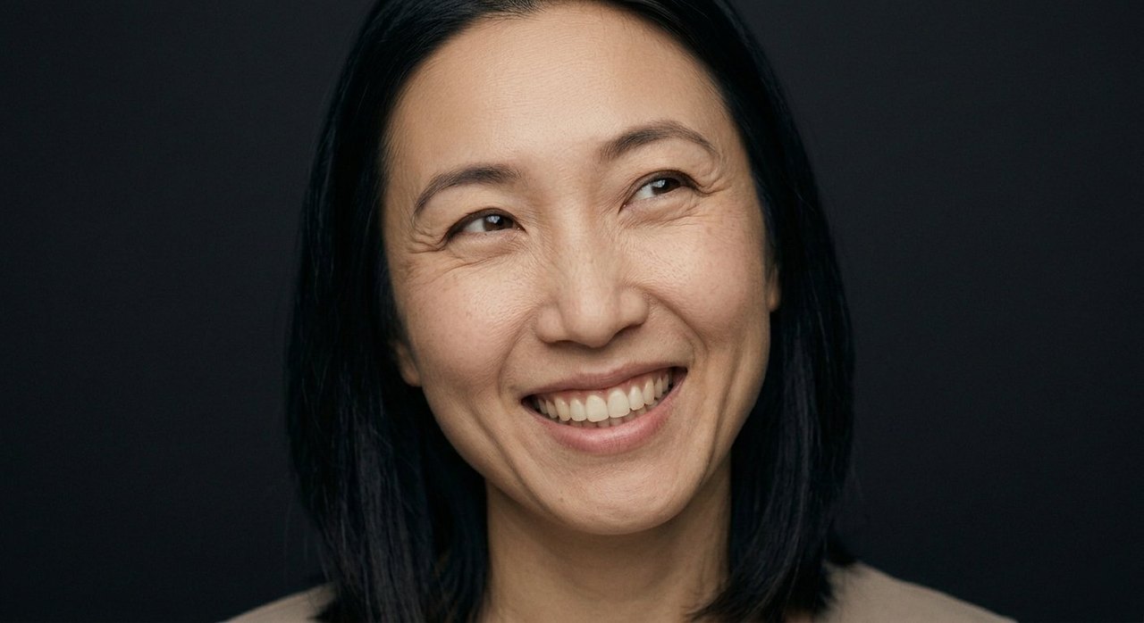 A woman's face showing joy: a radiant smile, a tilted head, eyes warm with joy.