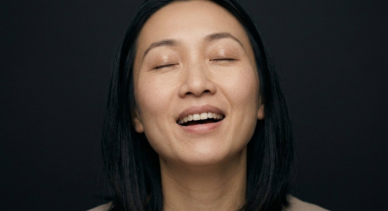A woman's face showing rapture: eyes closed, lips parted, head tilted in quiet absorption.