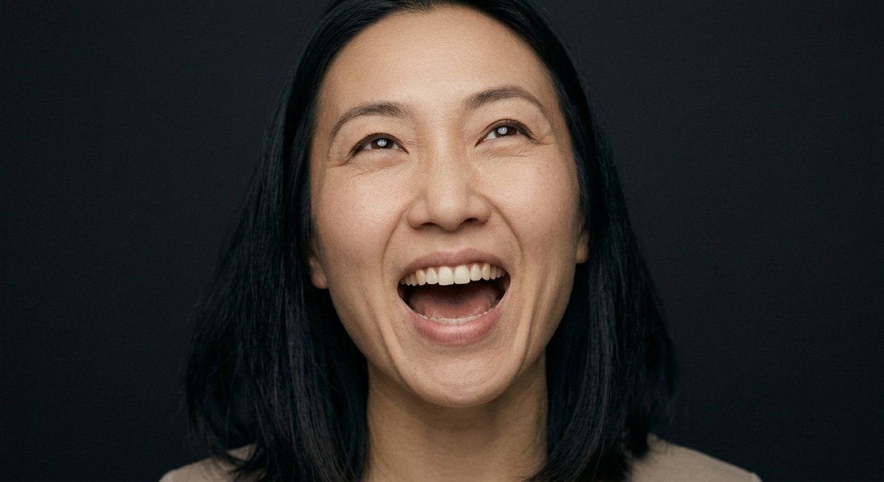 A woman's face showing triumph: an open laugh, eyes lifted, a victorious radiance.