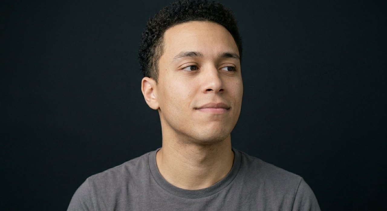 A man's face showing vanity: a pleased sideways smirk, raised chin, appraising look.