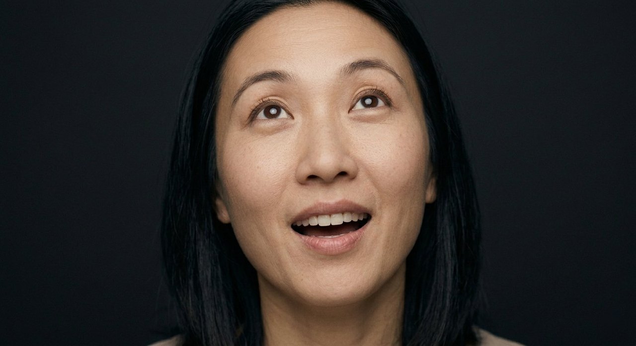 A woman's face showing wondrous: lips parted, eyes lifted in wonder, a bright amazement.